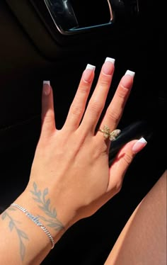 a woman's hand with white nail polish and gold ring on her left wrist