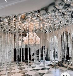 a room filled with lots of shiny balls and chandelier hanging from the ceiling