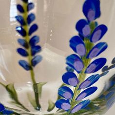 some blue flowers are in a glass bowl