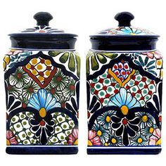 two colorful canisters with black lids and designs on the top one is decorated with flowers