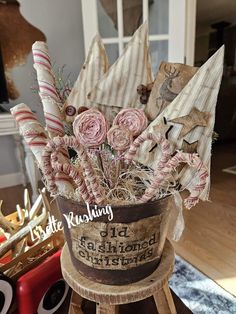 a basket filled with candy canes and flowers on top of a wooden stand in front of a fireplace