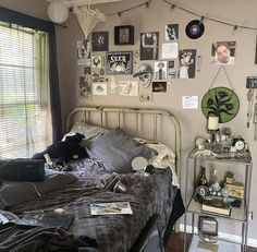 a bed room with a neatly made bed and lots of pictures on the wall above it