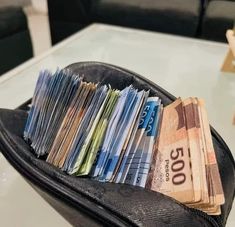 a black bag filled with lots of money sitting on top of a table