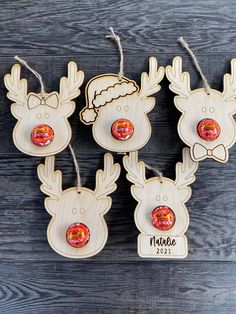 four wooden reindeer ornaments hanging from strings on a wood background with the name nicole written in red