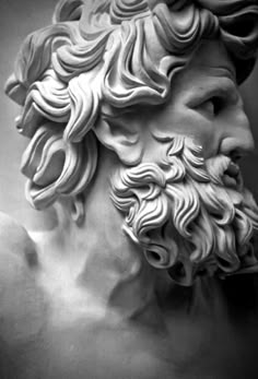 a black and white photo of a statue of a man's head with wavy hair