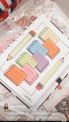 a close up of a notepad with pencils and paper on top of it