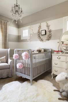 a baby's room with two cribs and a chandelier