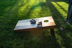 a person standing next to a wooden table on top of green grass with shoes on it