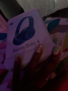 a woman's hand holding an electronic device with the words beats solo on it