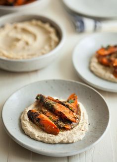 two plates with food on them sitting on top of a white table next to each other