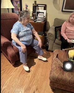 two older women sitting in chairs talking to each other