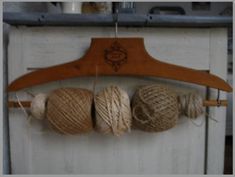 three balls of yarn hanging from a wooden hanger