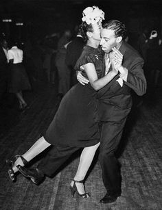 an old photo of two people dancing on the dance floor