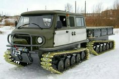 an army vehicle is parked in the snow with tracks attached to it's sides