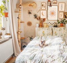 a cat laying on top of a bed in a bedroom next to a window with pictures above it