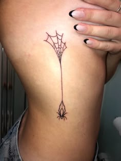 a spider web tattoo on the back of a woman's right side ribcage