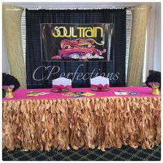 the table is set up with pink and gold decorations