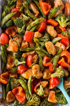 a pan filled with chicken, broccoli and peppers