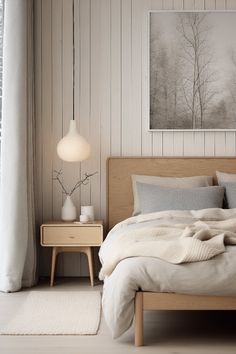 a bed sitting next to a window in a room with white walls and wooden furniture