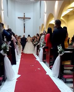 a bride and groom are walking down the aisle at their wedding ceremony in a church