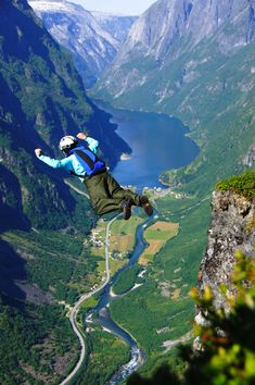 a man flying through the air while riding a skateboard on top of a mountain