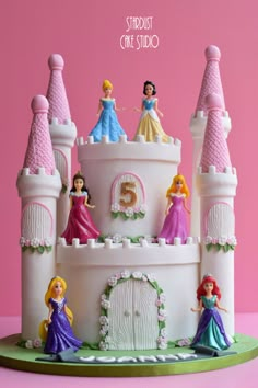 there is a cake made to look like a castle with princesses on it and the words, sweetest one studio