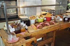 a wooden table topped with lots of different types of breads and muffins