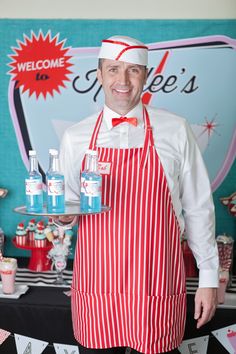 a man in an apron holding two bottles of water