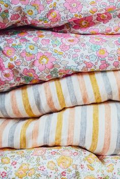 a stack of colorful striped and flowered sheets