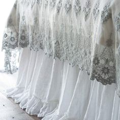 several white bedspreads are lined up against the wall