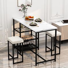 a dining table with two stools next to it