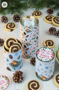 cookies in tins and pine cones on a table