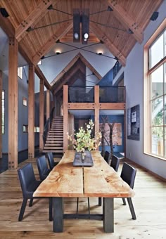 a large wooden table sitting in the middle of a room with lots of chairs around it