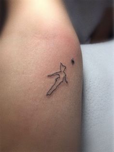 a small tattoo on the back of a woman's shoulder, depicting a cat and stars