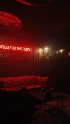 a red couch sitting in the middle of a room next to a sign that says museum for the people