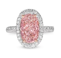 a fancy pink diamond ring with diamonds around the band and an oval shaped center stone