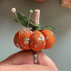 an orange pincus with two small pumpkins on it