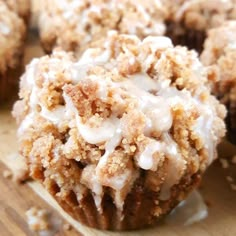 a muffin with white icing sitting on top of a wooden cutting board