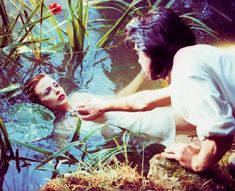 a man and woman in water with plants