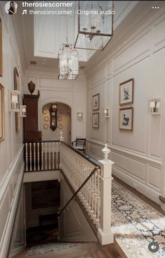 an elegant staircase with chandelier and pictures on the wall