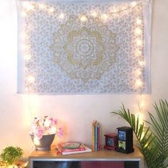 a room with a large tapestry hanging on the wall next to a potted plant