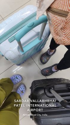 two people standing next to luggage on the floor