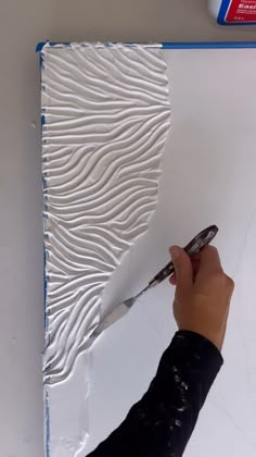 a person is using scissors to cut out the pattern on a piece of art paper