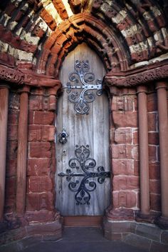 an old door in the middle of a stone building with columns and crosses on it