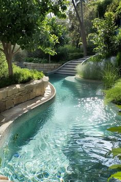 an outdoor swimming pool with steps leading up to the water's edge and trees in the background