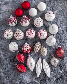 christmas ornaments laid out on a gray furnishing with red and white baubles