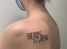 a woman with a tattoo on her upper back shoulder that says the wild and zebra