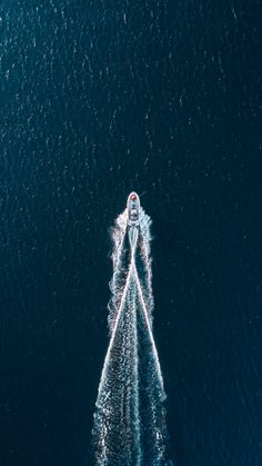 an aerial view of a speed boat in the middle of the ocean, taken from above