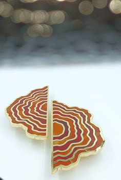 an orange and red brooch sitting on top of a white table