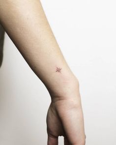 a small star tattoo on the left wrist is shown in this image, it looks to be